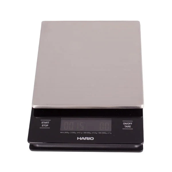 Black Comandante coffee grinder with Hario V60 metal drip scale for precise brewing and grinding coffee beans.