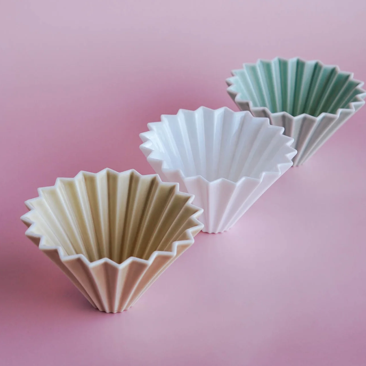 Orange Comandante coffee grinder with Origami Dripper S for precise brewing, featuring a sleek, compact design.