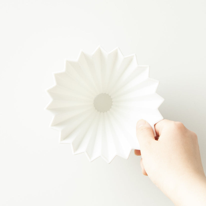 Pink Comandante Origami Dripper M coffee grinder with sleek design and textured surface for precise brewing.