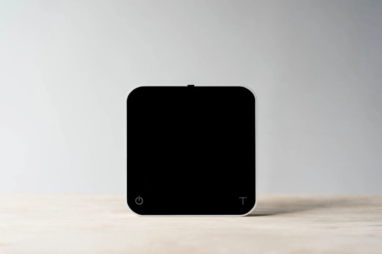 Comandante coffee grinder alongside Acaia Pearl 2021 coffee scale in pitch black, showing high-precision brewing equipment.