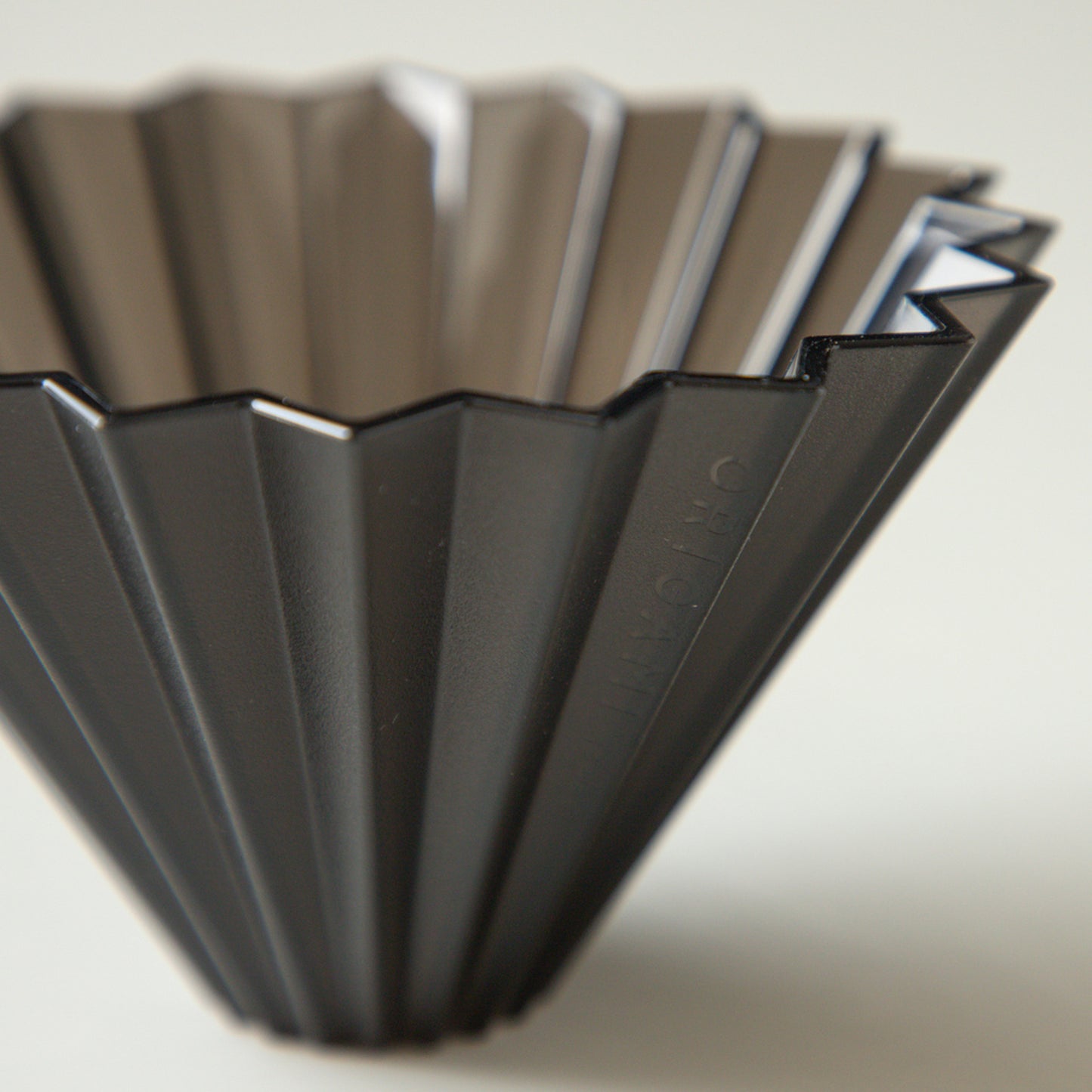 Black Comandante Origami Air S plastic coffee grinder with stainless steel burrs and compact design.