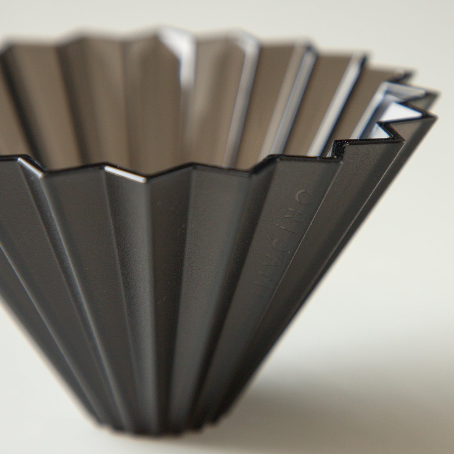 Black Comandante Origami Air S plastic coffee grinder with stainless steel burrs and compact design.