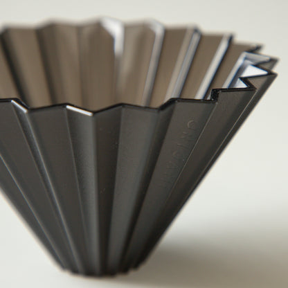 Black Comandante Origami Air S plastic coffee grinder with stainless steel burrs and compact design.