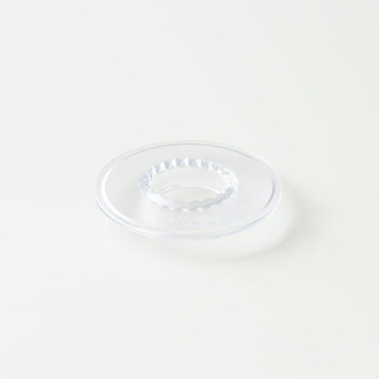 Clear holder for Origami coffee grinder by Comandante, shown with the grinder inside for secure storage and display.