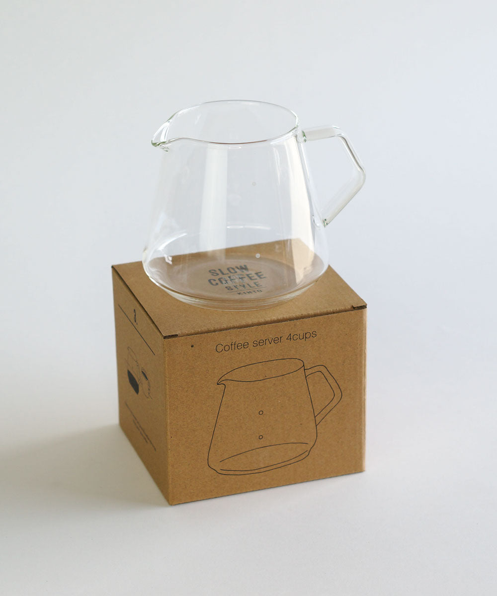 Comandante coffee grinder with clear Kinto 4-cup coffee server, showing the grinder's ceramic burrs and the glass server.