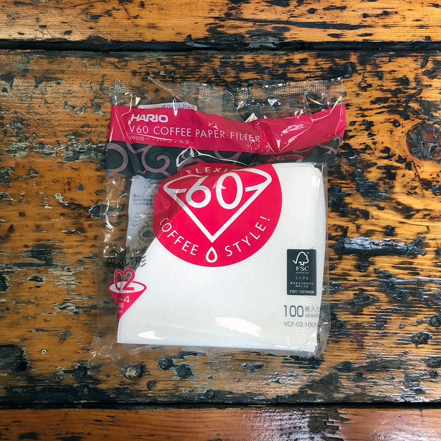 Comandante coffee grinder with Hario V60 Size 02 coffee paper filters for brewing coffee.