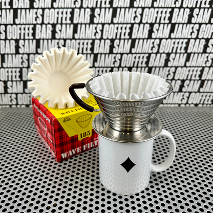 Comandante Kalita filters 185 for coffee brewing, shown alongside a coffee grinder in this detailed product image.