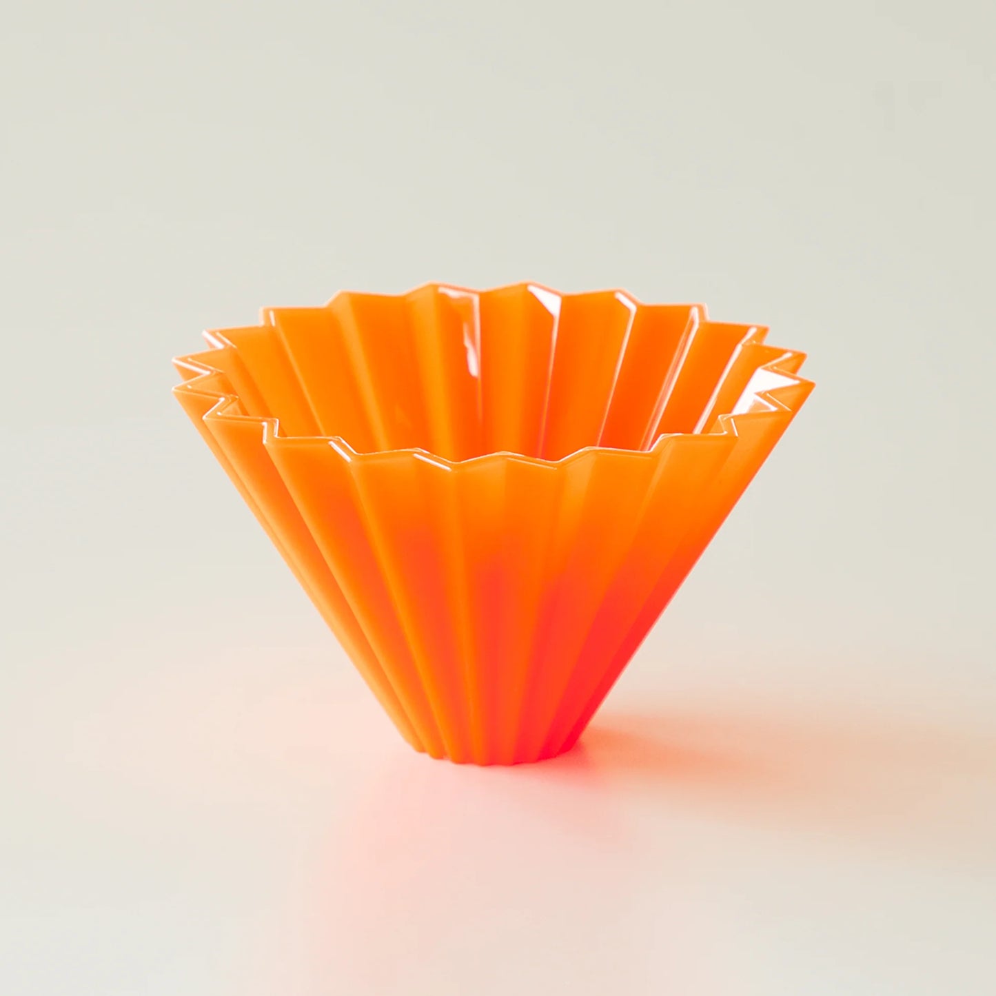 Pink Comandante Origami Air S plastic coffee grinder with a compact design and durable construction.