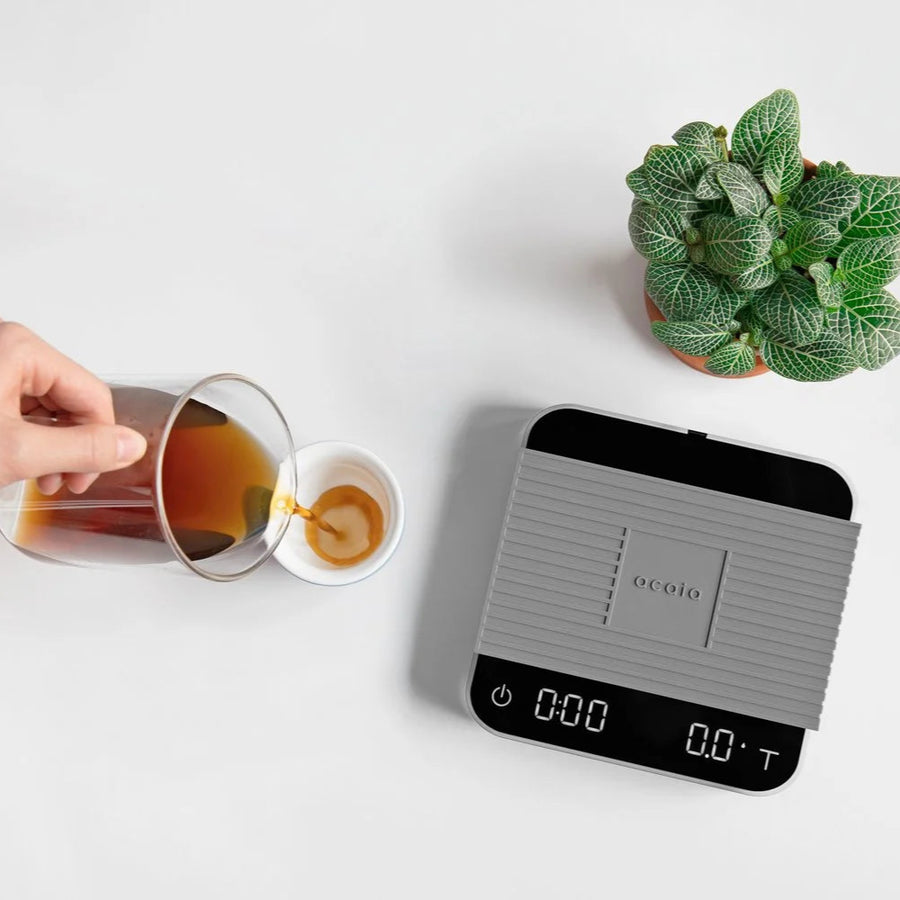 Comandante coffee grinder with Acaia Pearl 2021 pitch black coffee scale, detailed view of the sleek white grinder and digital scale.