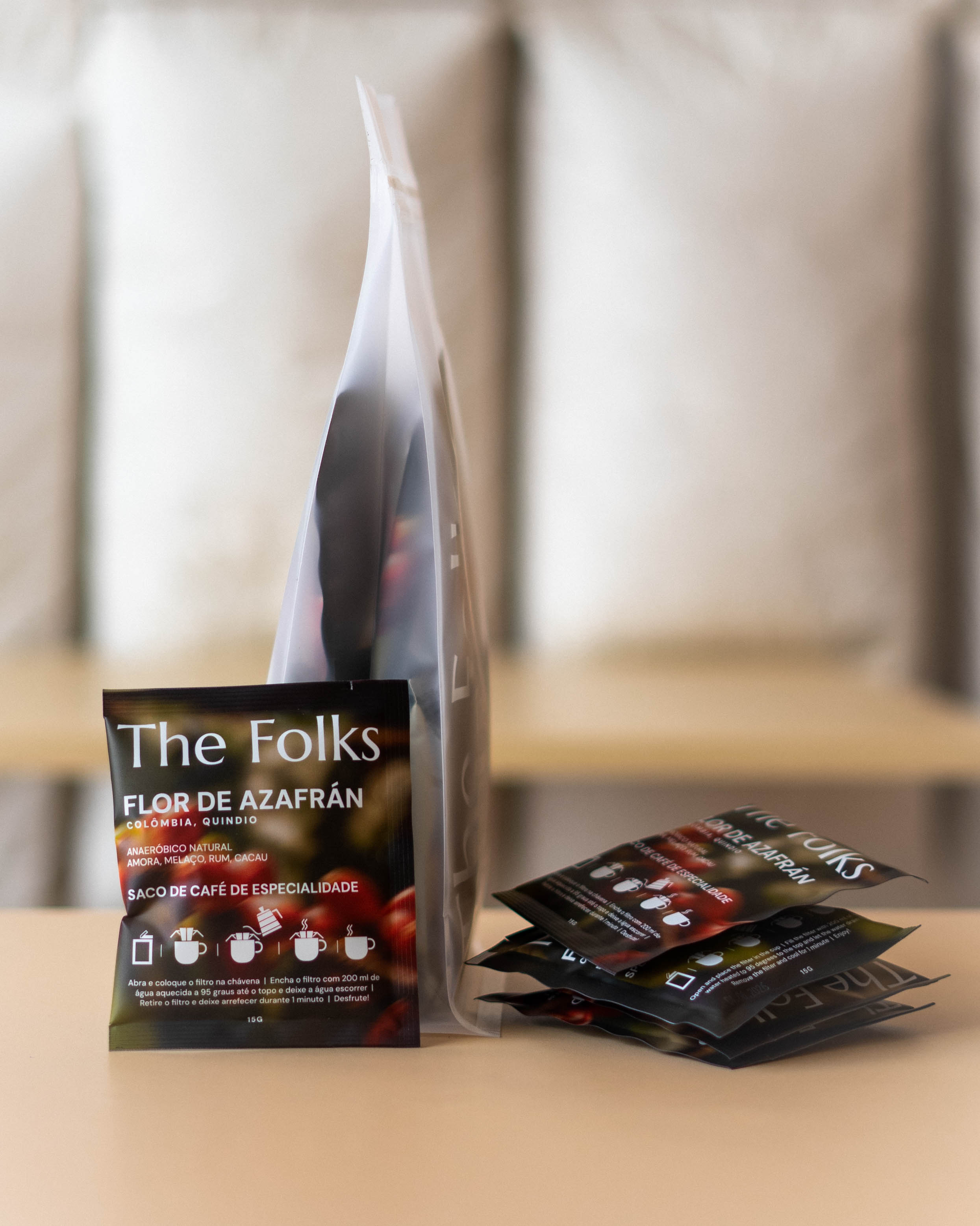 Pack of The Folks Colombia drip coffee beans with Flor de Azafrán label, showcasing fresh coffee beans in a natural setting.